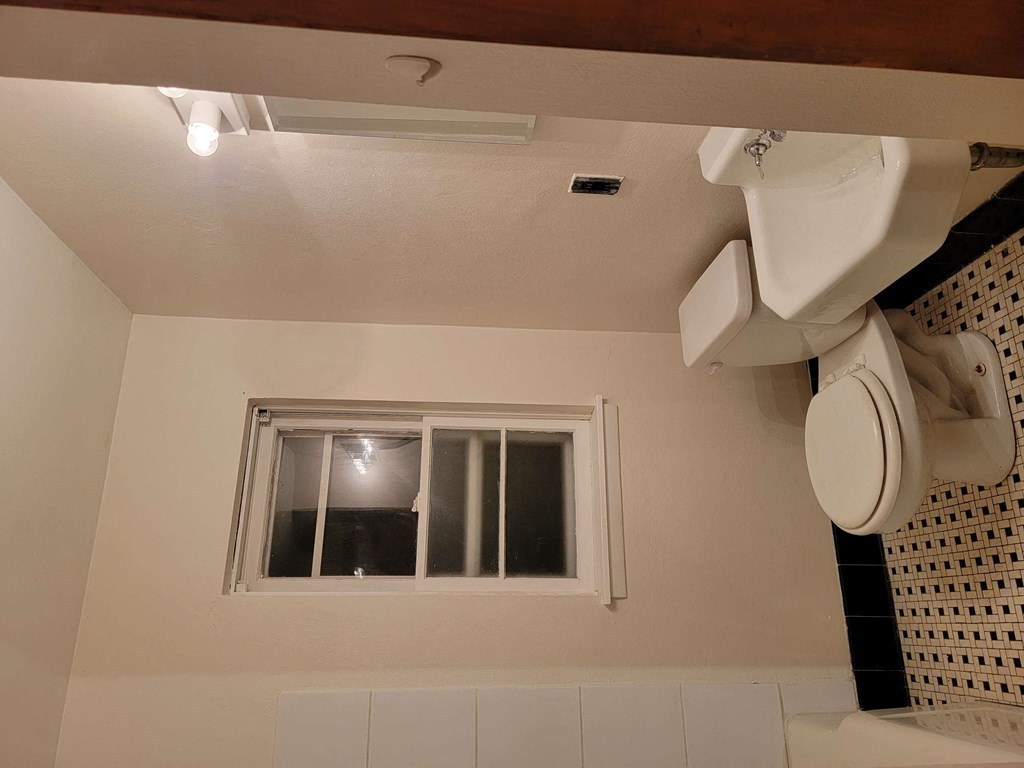 a bathroom with a toilet and a window