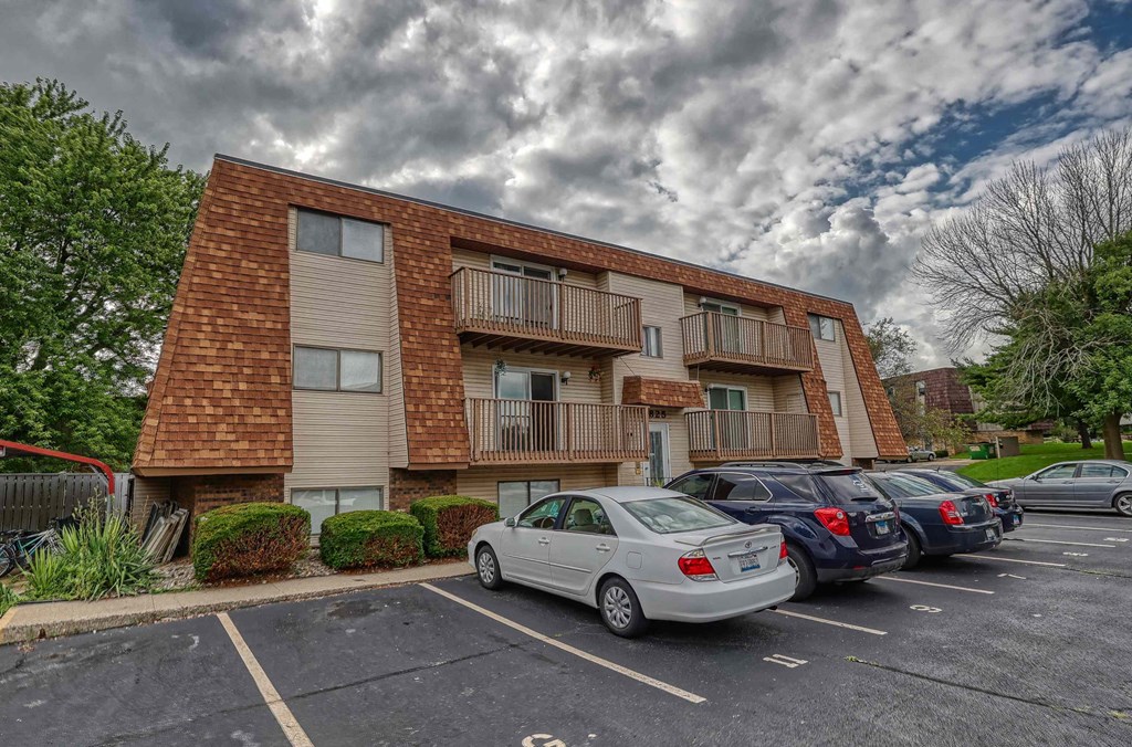 A parking lot with cars and a building in the background.