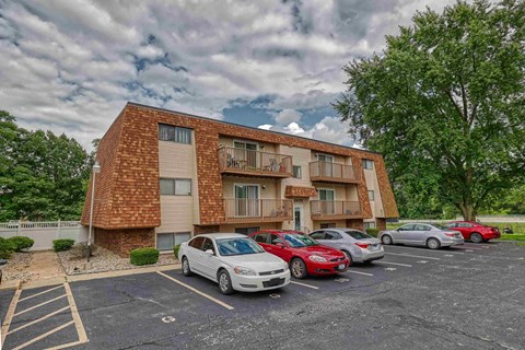 A parking lot with cars and a building in the background.