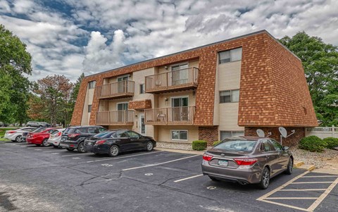 an apartment building with a parking lot full of cars