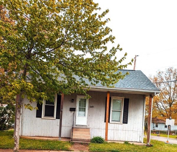 a white house with a tree in front of it
