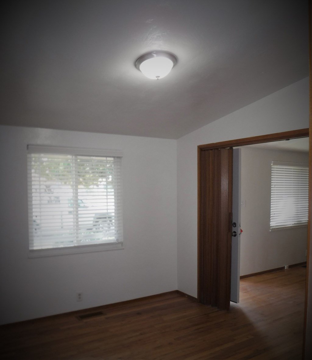 an empty room with a window and a door