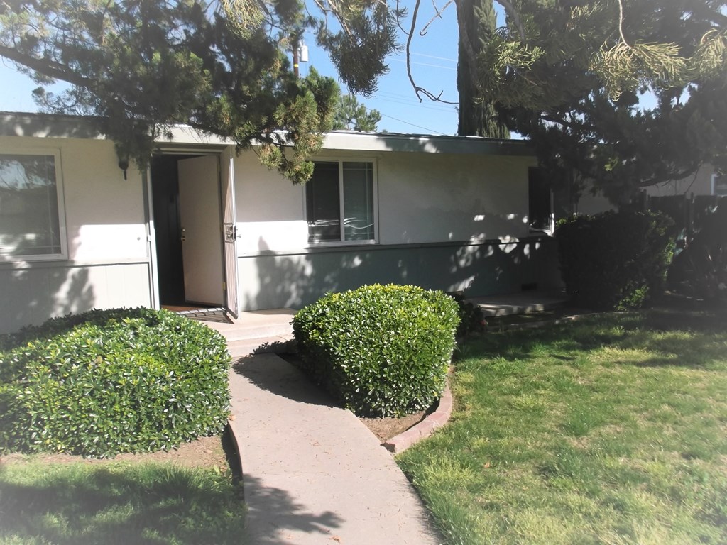 the front of a house with a sidewalk and a door