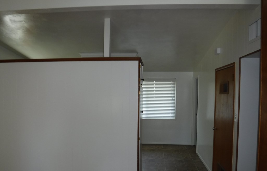 an empty room with white walls and a window and a door