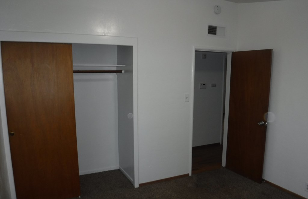 an empty room with a refrigerator and a door