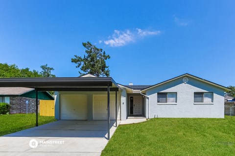 a white house with a covered porch and a lawn