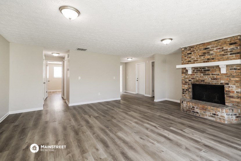a living room with a fireplace and a wooden floor