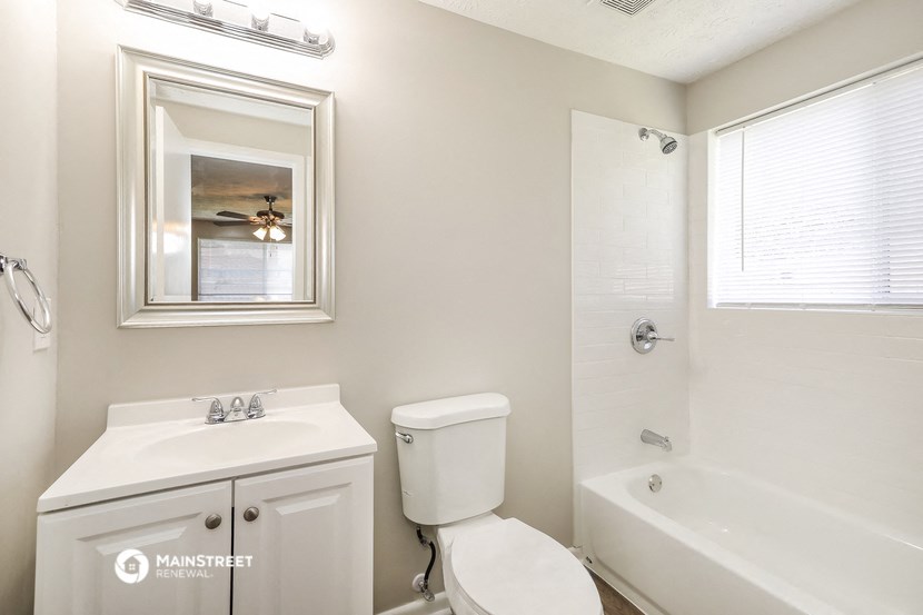 a bathroom with a toilet and a tub and a sink