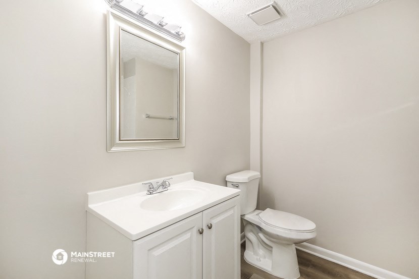 a bathroom with a sink and a toilet and a mirror