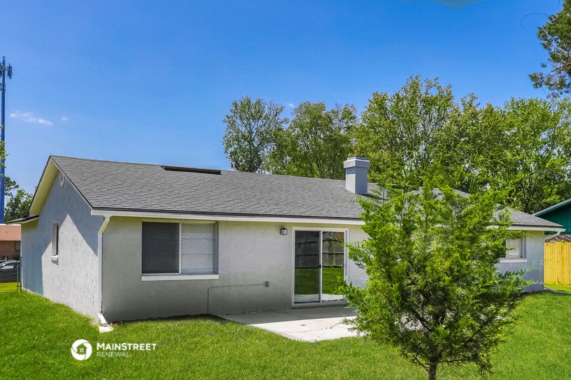 a small white house with a tree in front of it