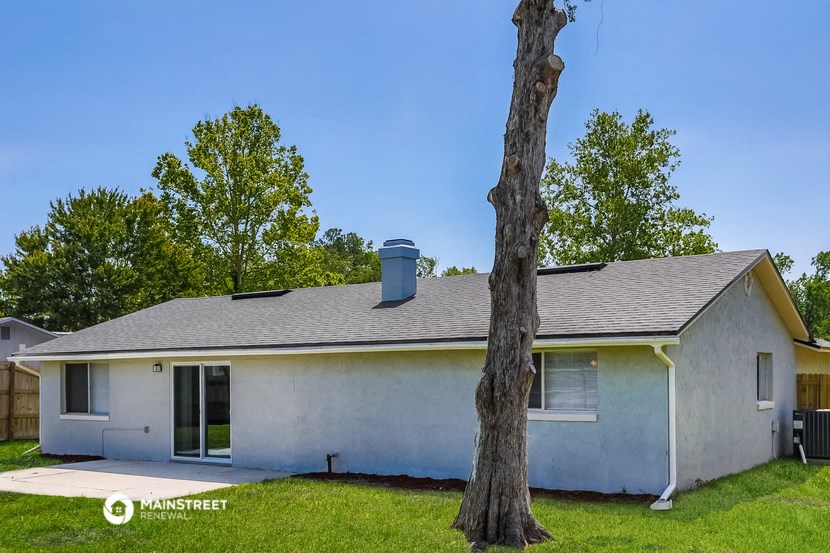 a white house with a tree in front of it