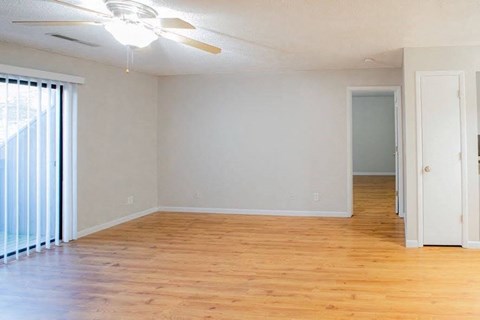 A room with wooden floors and a ceiling fan.