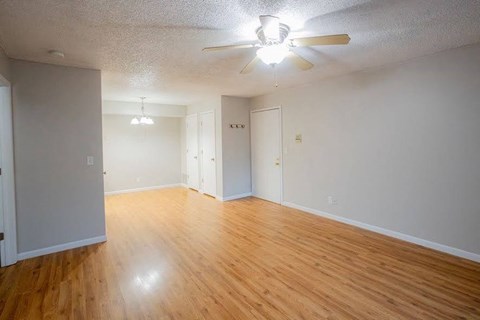 A room with wooden floors and a ceiling fan.