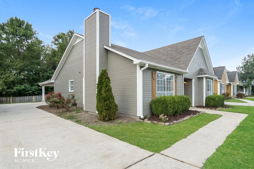 a gray house with a sidewalk in front of it