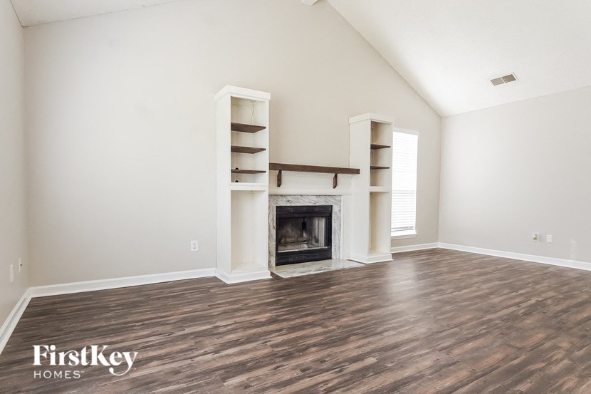 the living room with wood flooring and a fireplace
