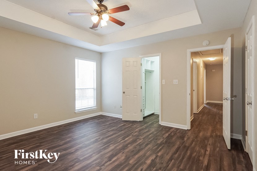 a living room with hardwood flooring and a ceiling fan