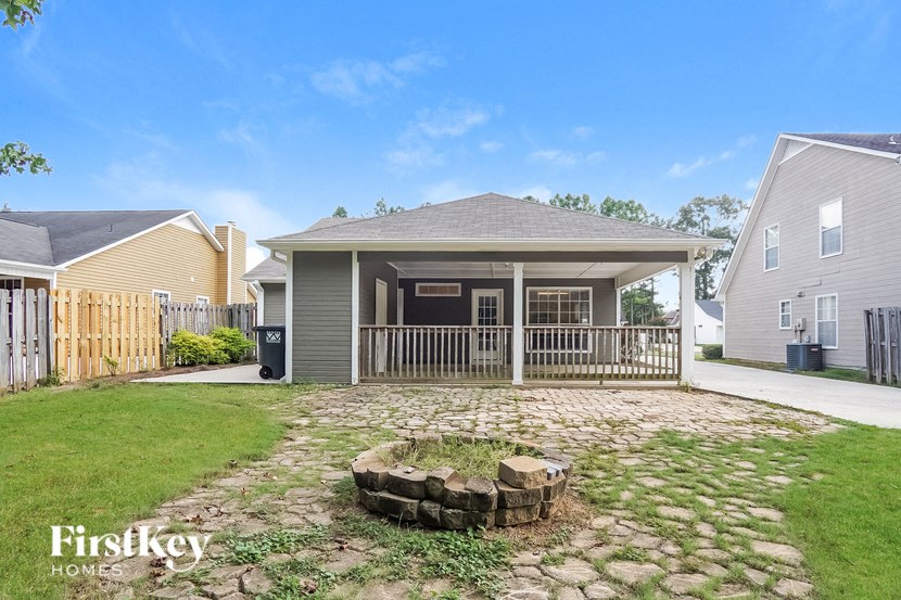 a backyard with a house and a yard with a retaining wall