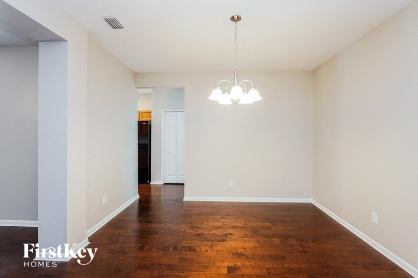 a empty living room with wood floors and a chandelier