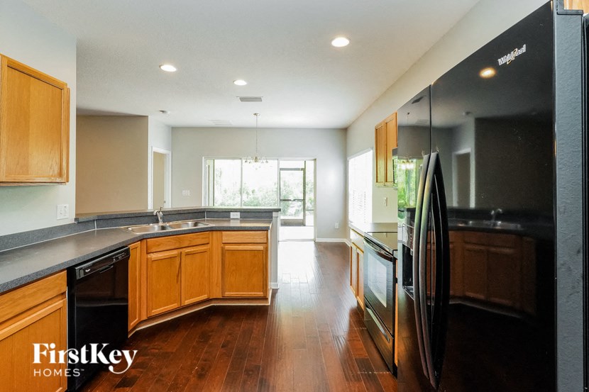 a large kitchen with black appliances and wood floors