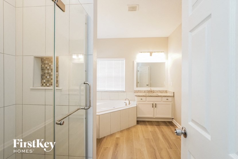a bathroom with a shower and a sink and a bath tub