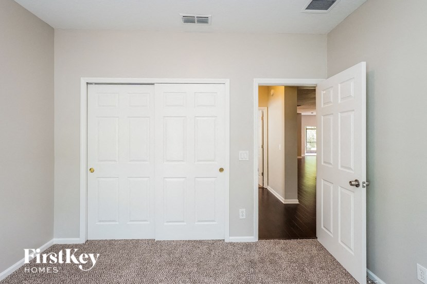 a bedroom with two closets and a door to a hallway