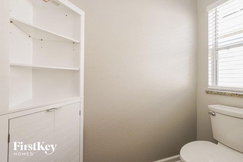 a bathroom with a toilet and a white cabinet