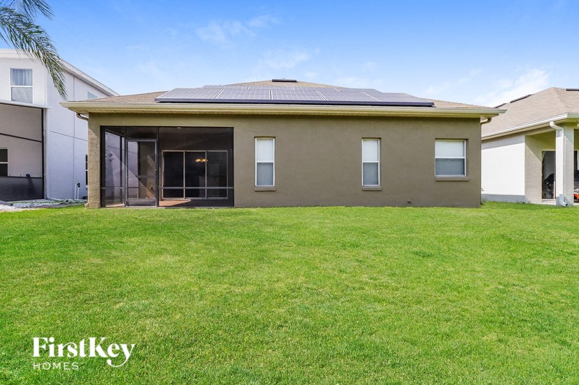 a home with a lawn and a house with a solar roof