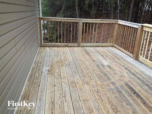 a deck with a wooden railing on a house