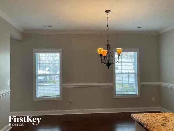 a dining room with a chandelier and two windows