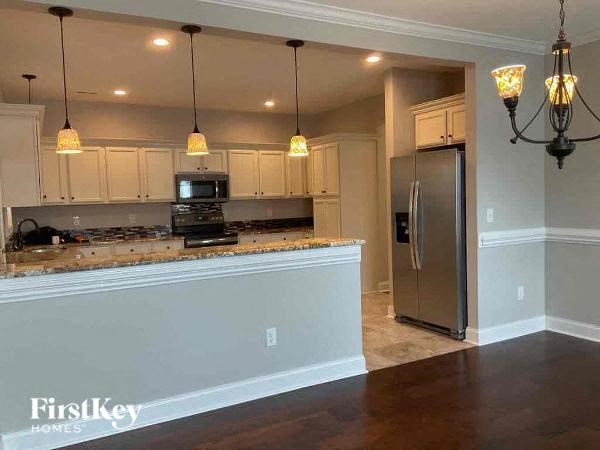 a kitchen with an island and a stainless steel refrigerator