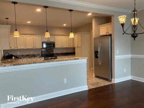 a kitchen with an island and a stainless steel refrigerator