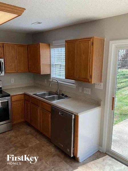 A kitchen with wooden cabinets and a white dishwasher.