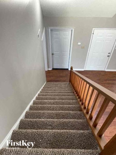 A staircase with a carpeted runner and wooden balusters.