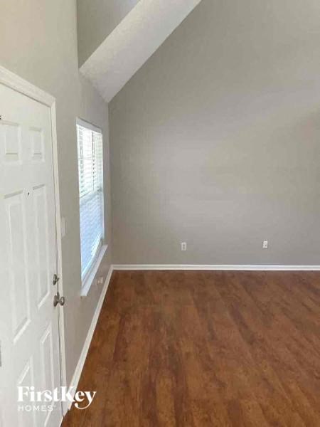 A room with wooden flooring and a white door.