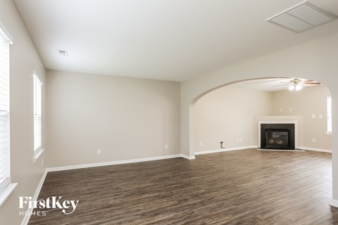 A spacious living room with a fireplace and wood flooring.