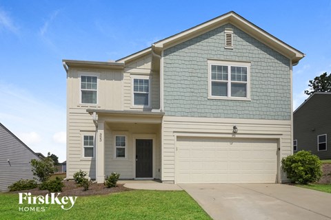 a beige and blue house with a garage door