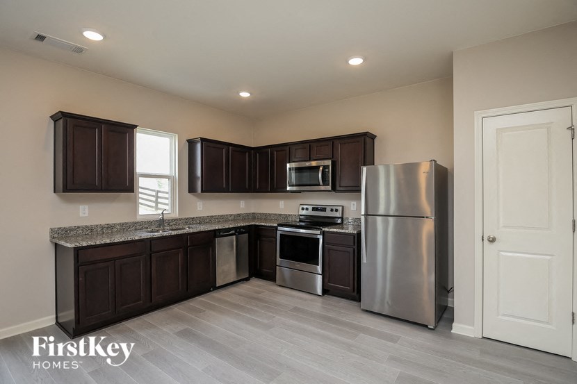 a kitchen with dark wood cabinets and stainless steel appliances