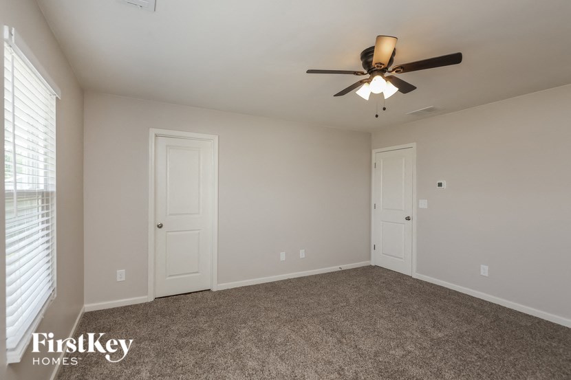 a bedroom with a ceiling fan and white doors