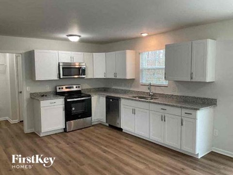 A kitchen with white cabinets and a granite countertop.