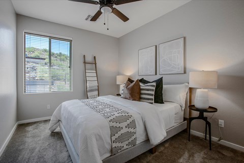 a bedroom with a bed and a ceiling fan