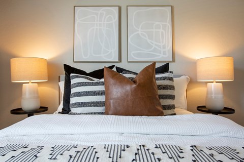 a bedroom with a bed and two pictures on the wall above it