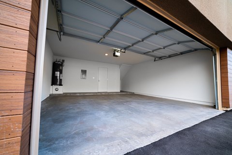 the interior of a garage with a concrete floor and a white wall