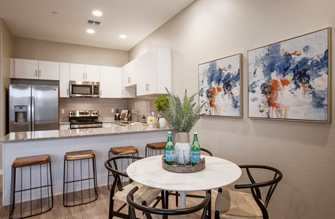 a kitchen with a counter and a table with stools