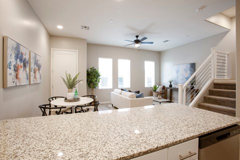 view of living room from kitchen of new home with granite counter top
