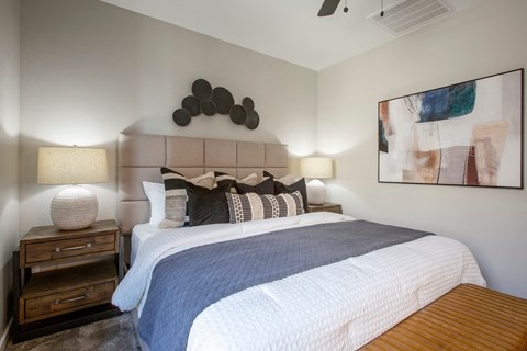 a bedroom with a large bed and a painting on the wall