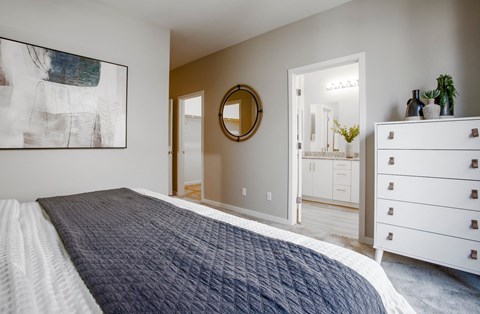 a bedroom with a bed and a bathroom with a sink