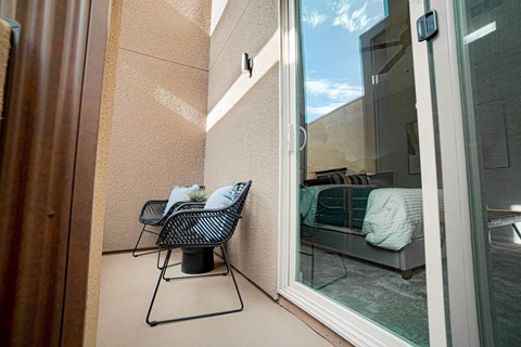 a balcony or terrace with a chair and a glass door