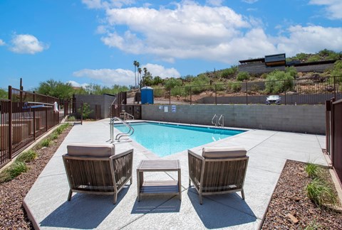 a pool with chairs and a table next to it