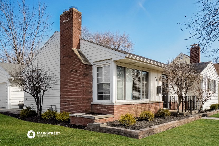 the front of a brick house with a yard and grass