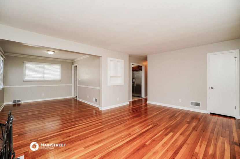the living room and dining room of a house with wood floors